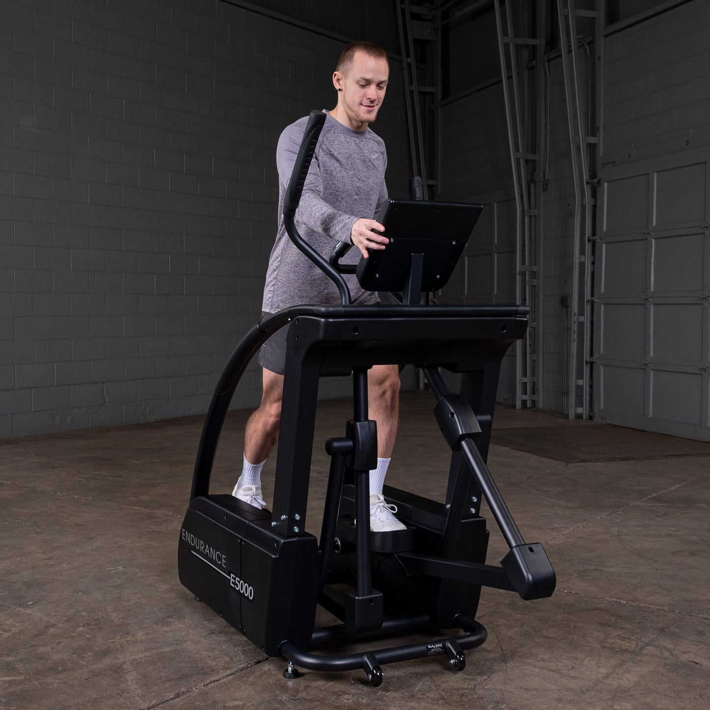Front angle view of Body-Solid E5000 elliptical showing oversized pedals and dual-action handlebars
