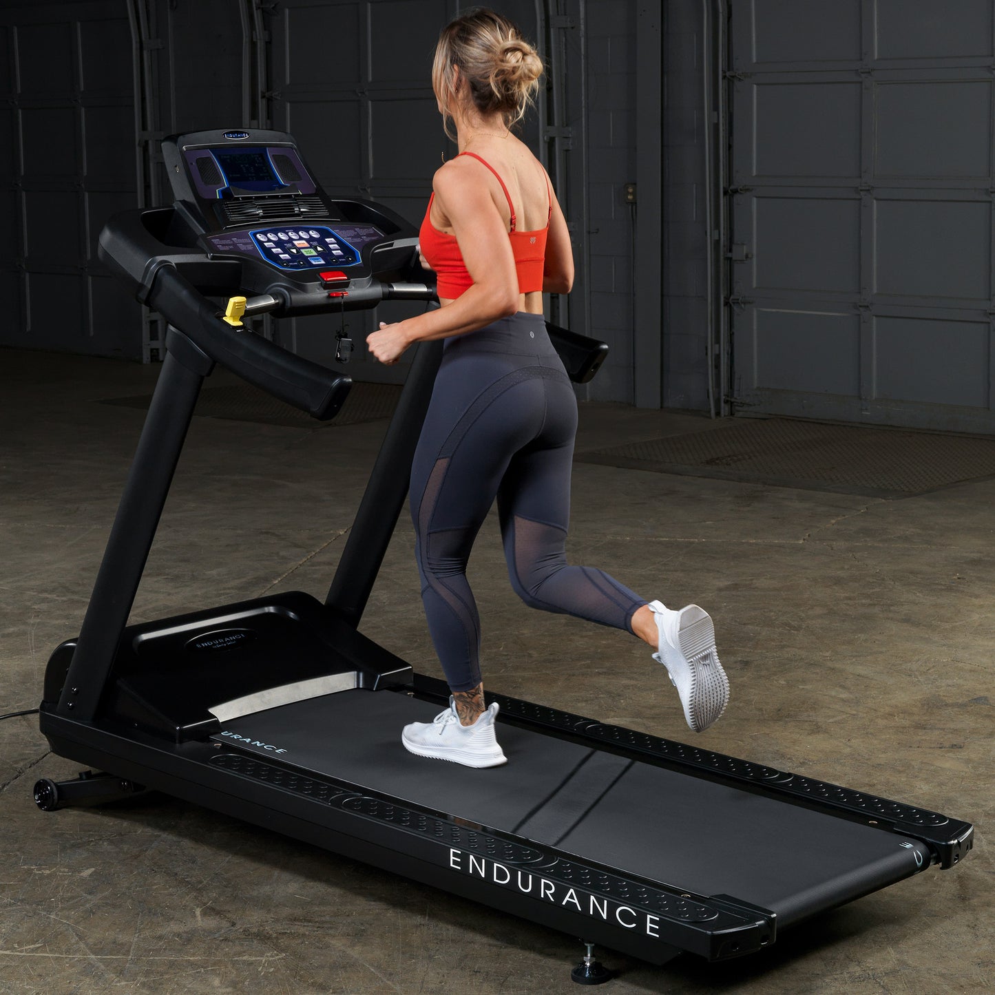 Woman running on the Body-Solid Endurance T150 Commercial Treadmill