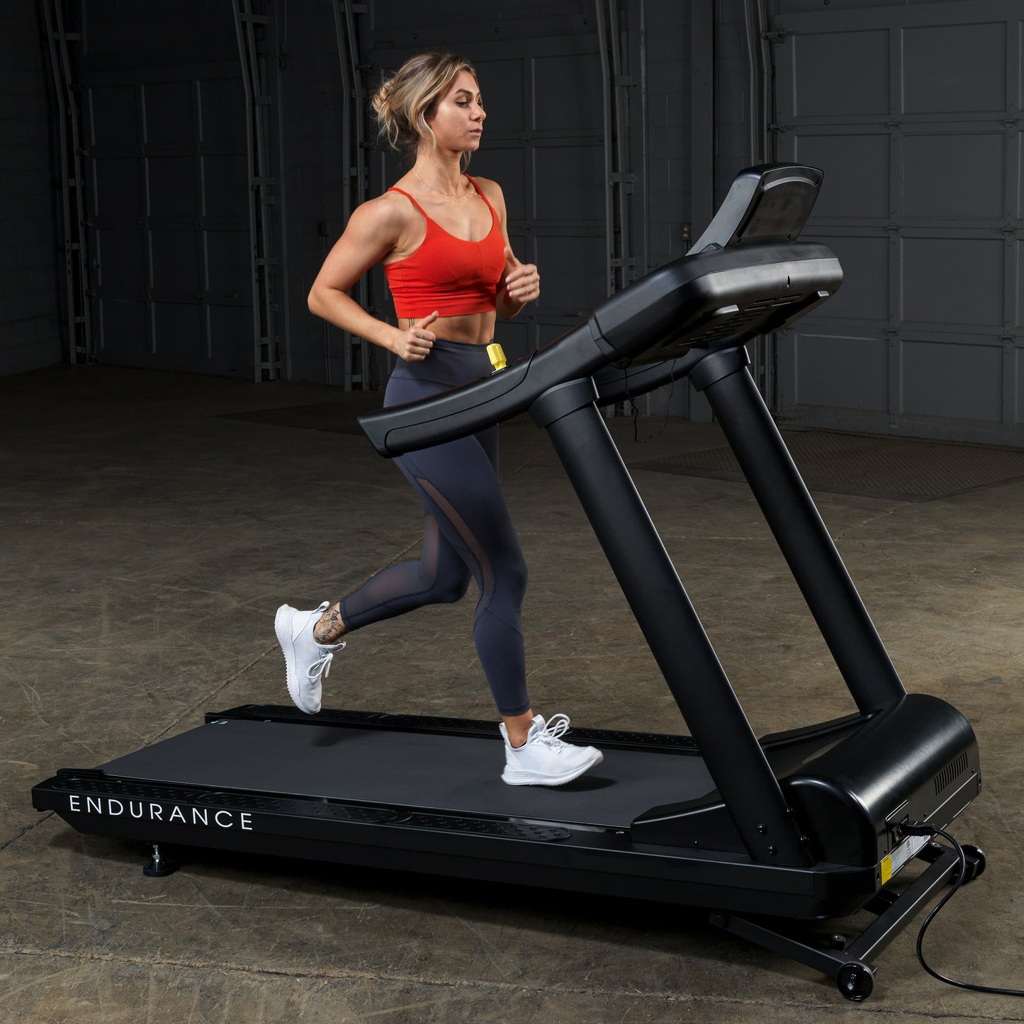 Woman running on the Body-Solid Endurance T150 Commercial Treadmill