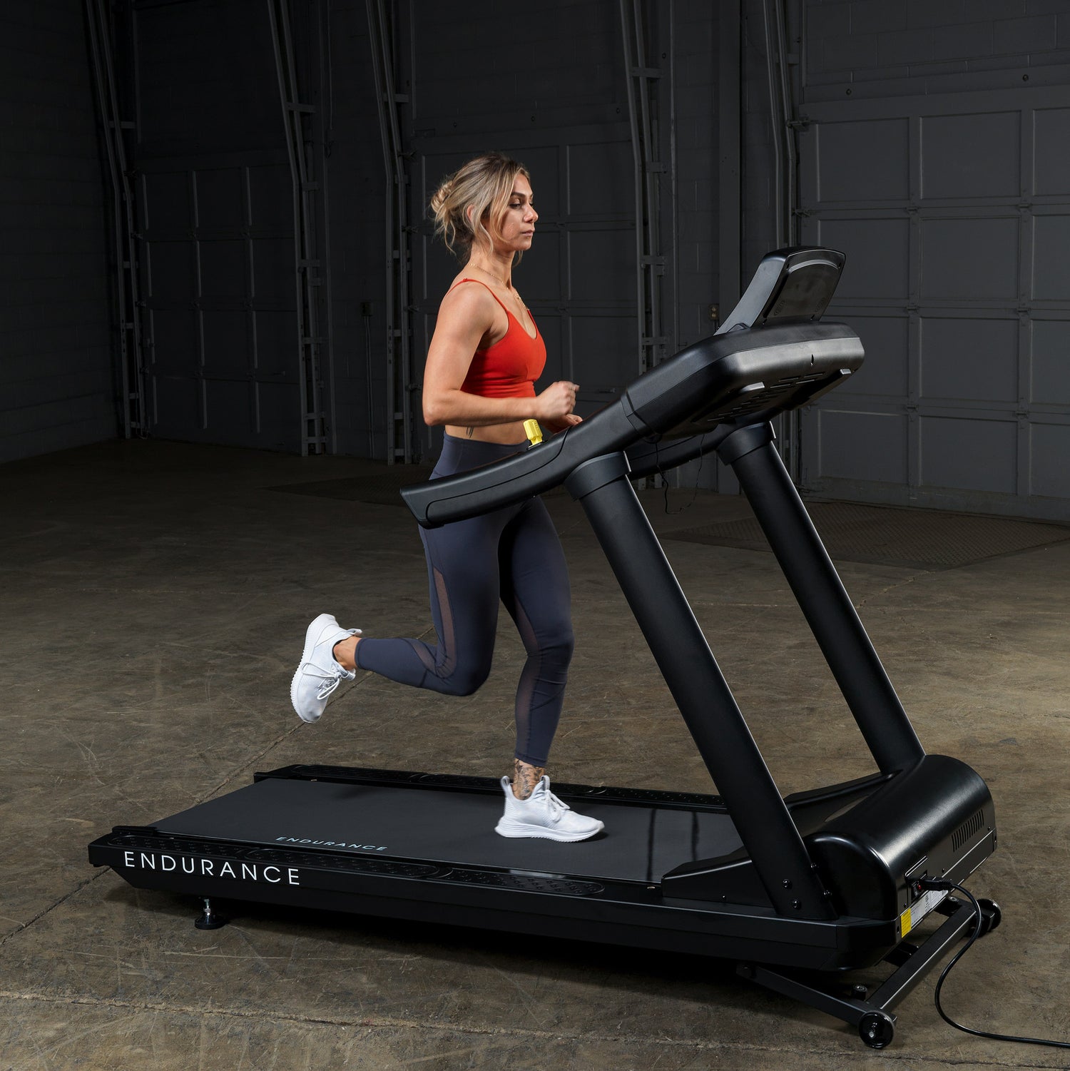 Woman running on the Body-Solid Endurance T150 Commercial Treadmill