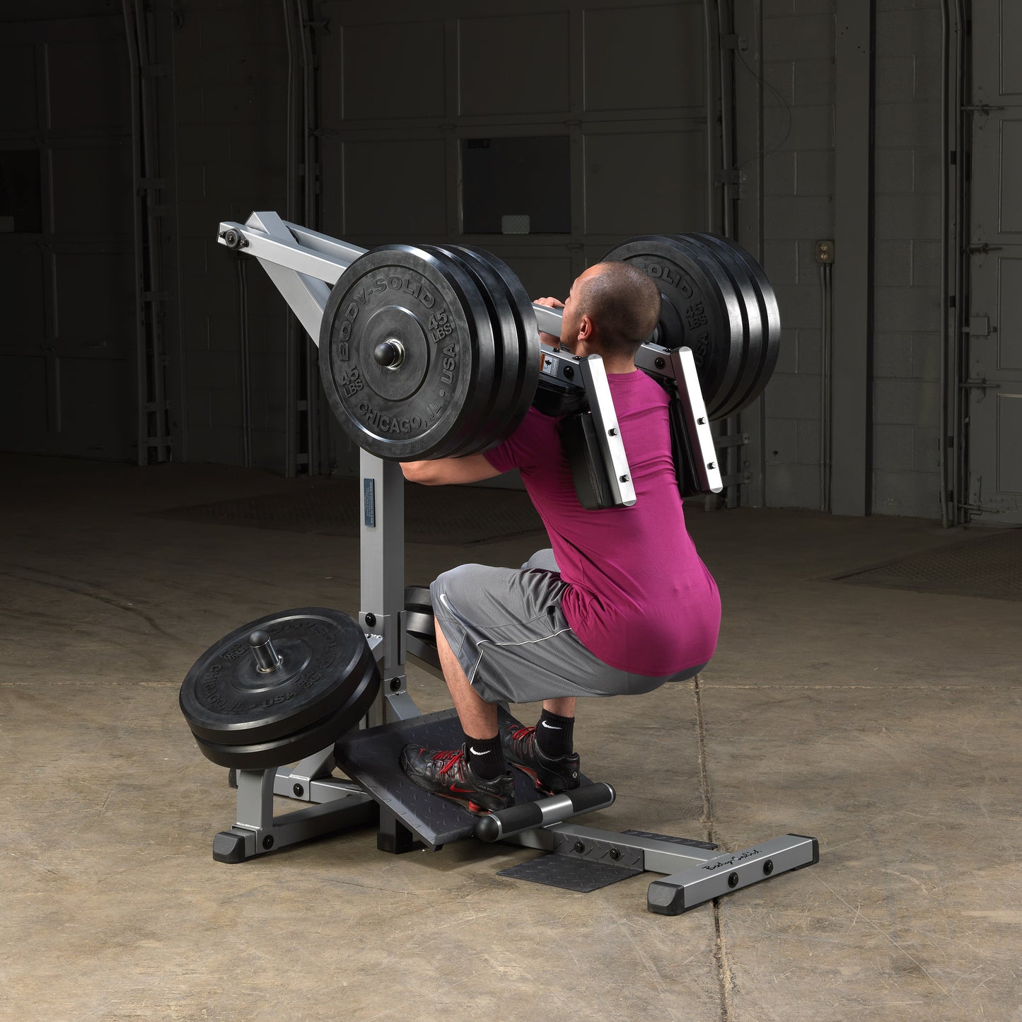 Athlete performing leverage squats on Body-Solid GSCL360 leg workout machine.