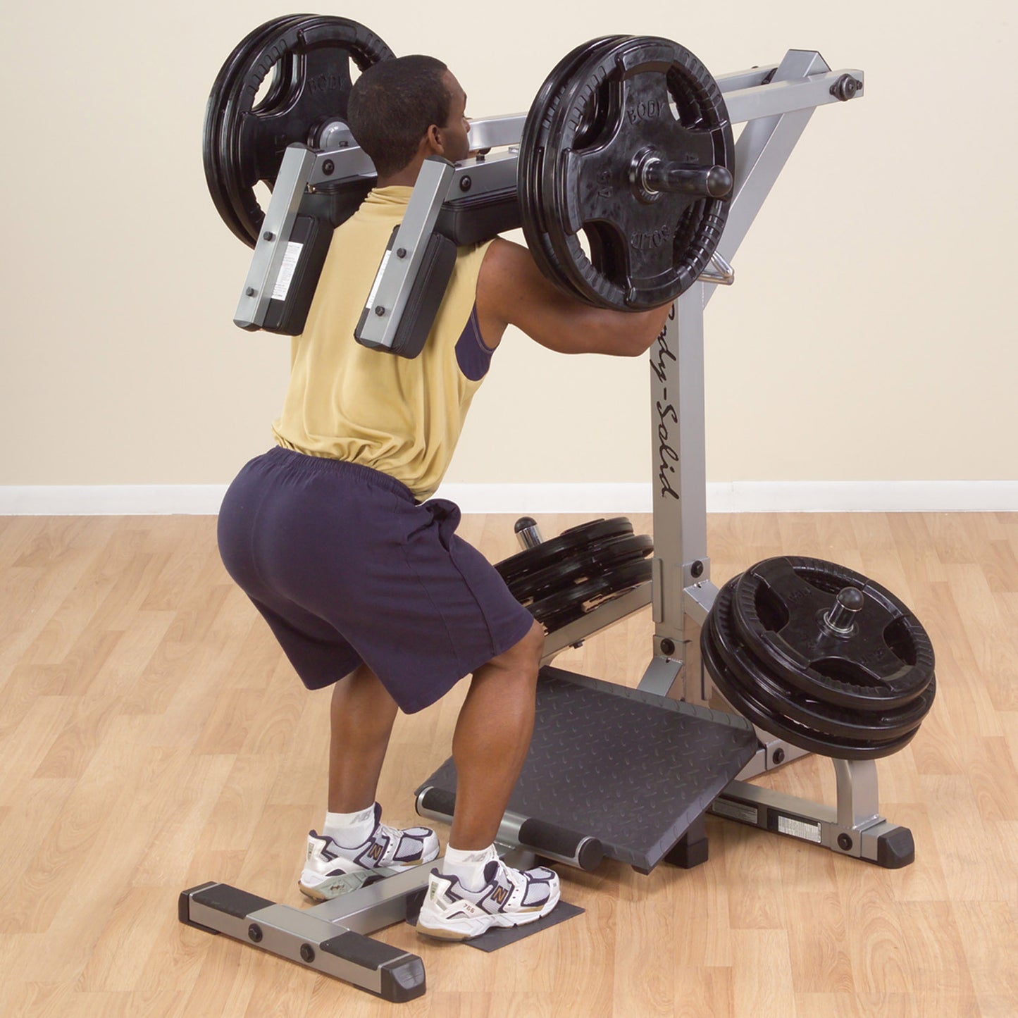 Athlete performing leverage squats on Body-Solid GSCL360 leg workout machine.