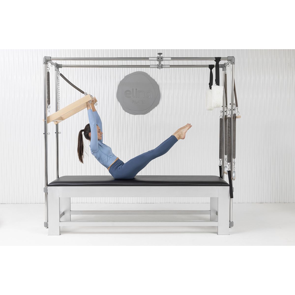 Woman doing workout on the Elina Pilates Classic Aluminum Cadillac trapeze