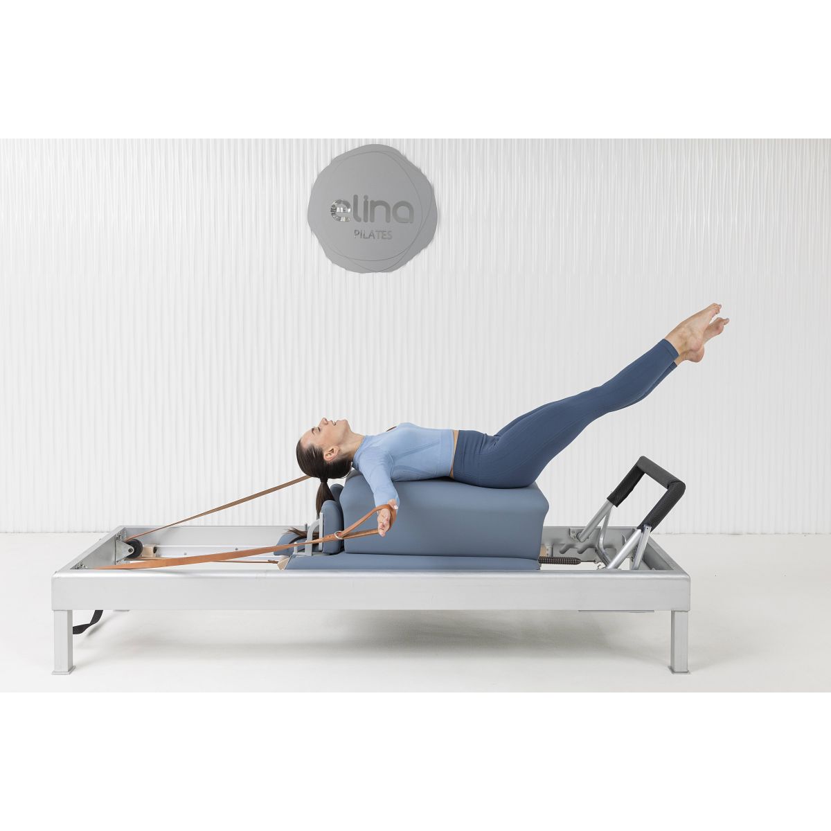 Pilates instructor demonstrating a jumpboard routine on the Elina Pilates Classic Aluminum Reformer 86″ to enhance cardio and tone.