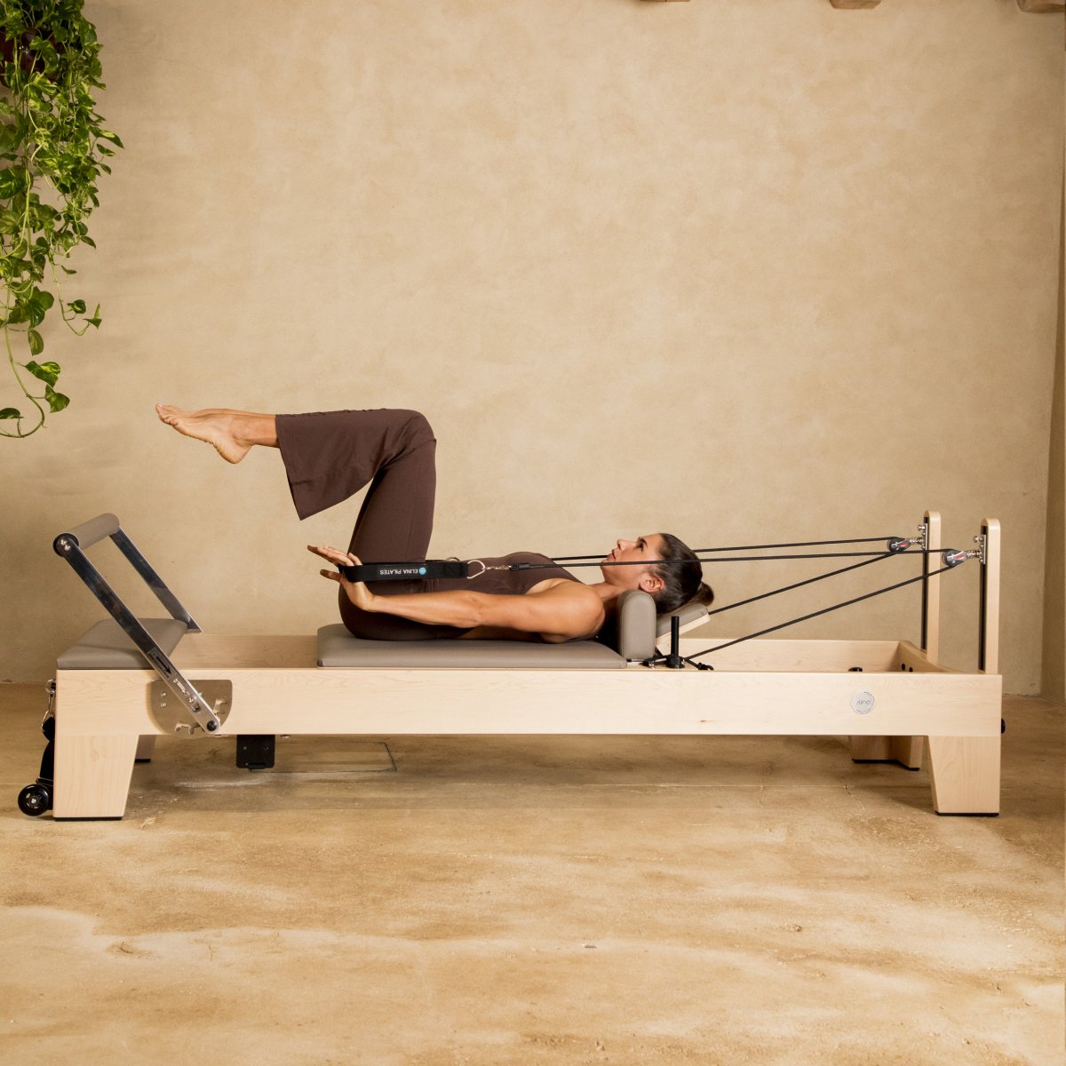 Pilates instructor performing core strengthening exercises on Elina Pilates Elite Wood Reformer with black upholstery