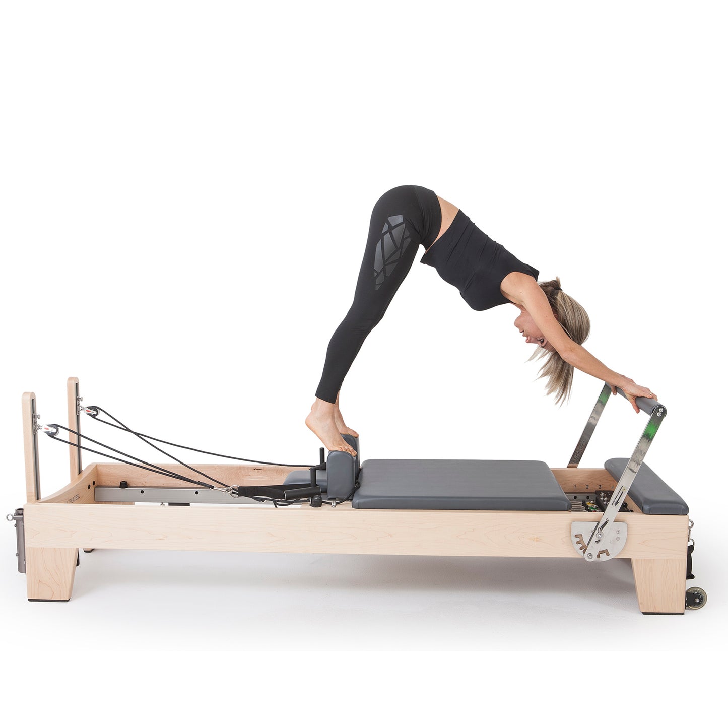 Pilates instructor performing core strengthening exercises on Elina Pilates Elite Wood Reformer with grey upholstery