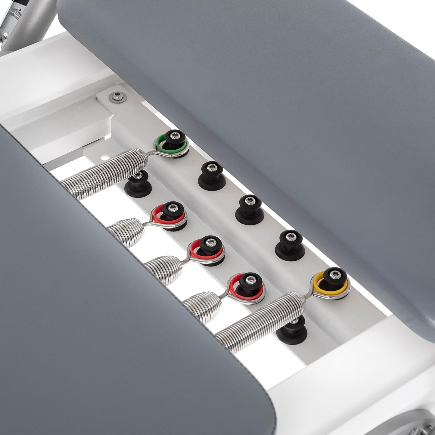 Color-coded alloy springs attached to the Elina Pilates Nubium Reformer showing different resistance levels