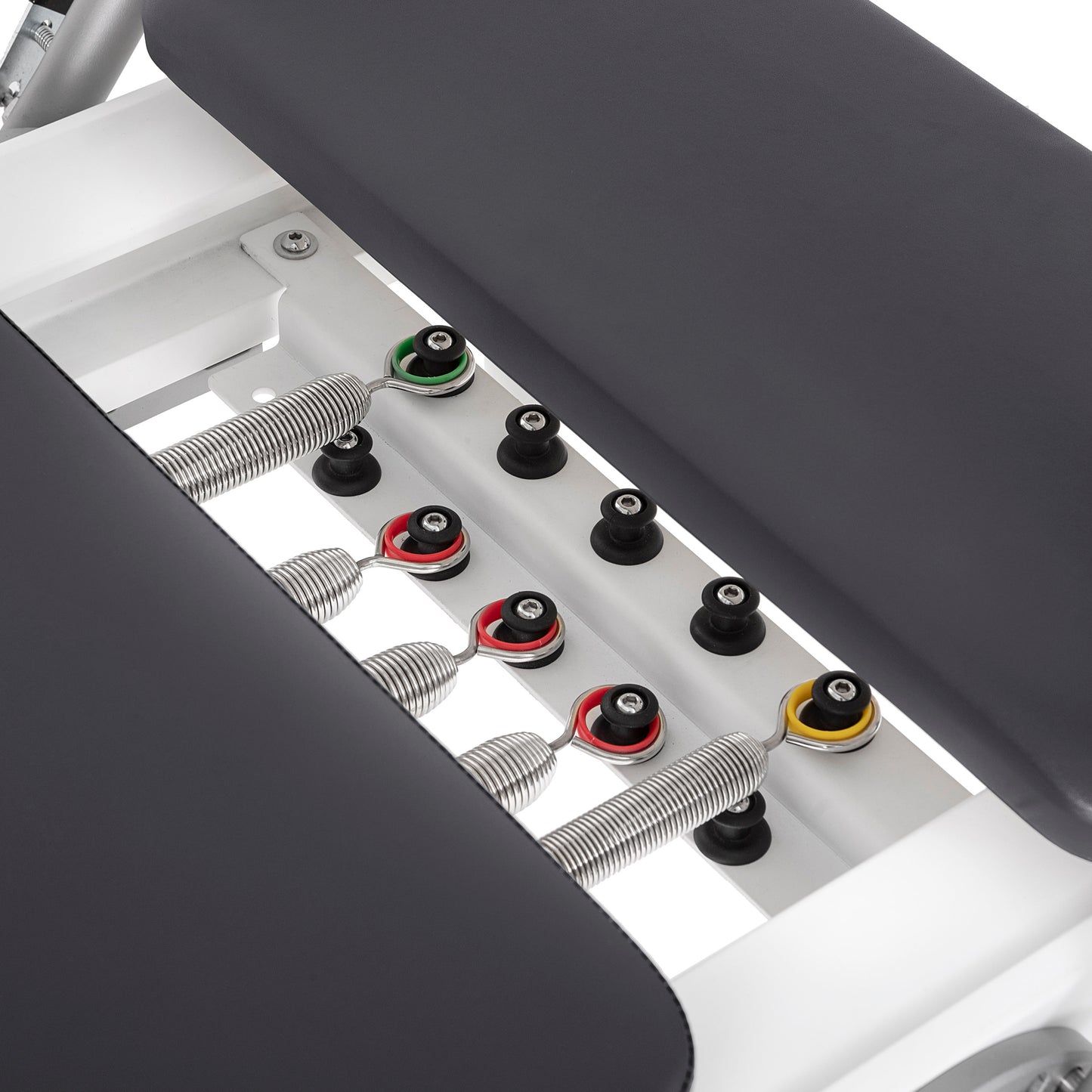 Color-coded alloy springs attached to the Elina Pilates Nubium Reformer showing different resistance levels