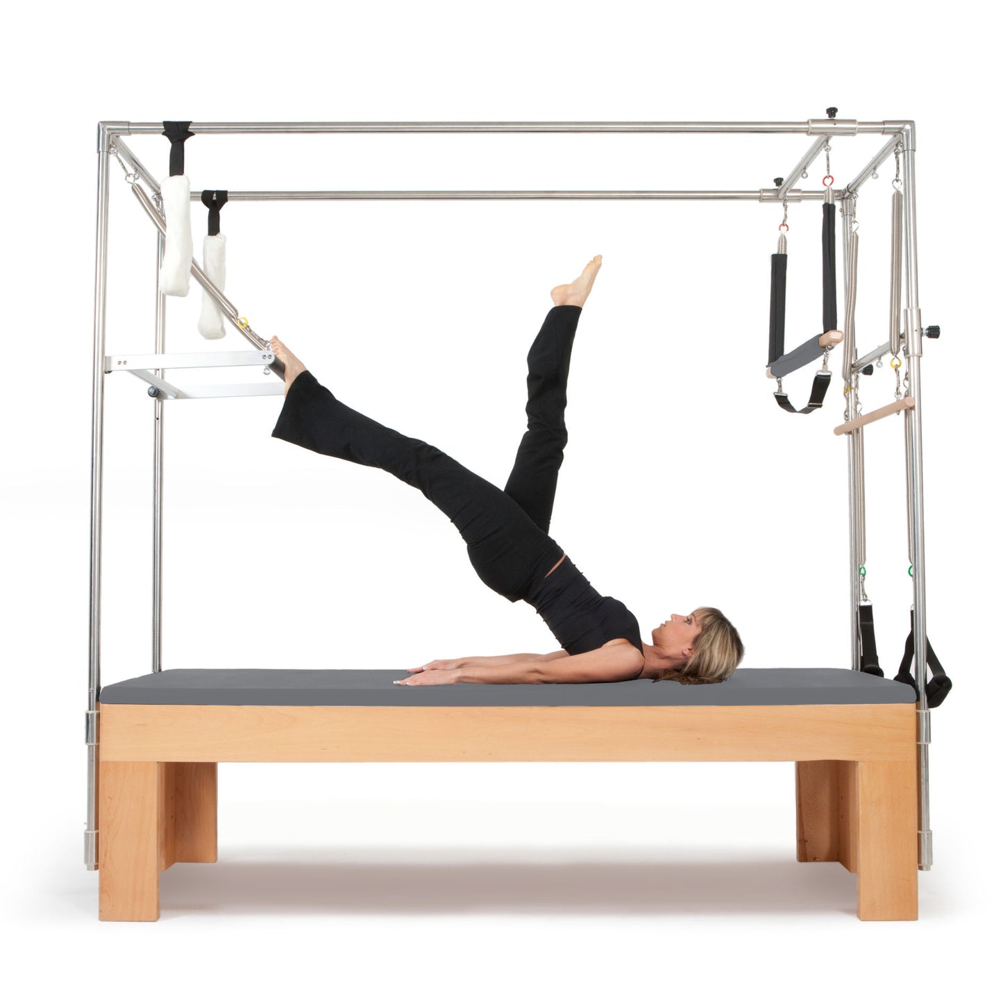 User performing trapeze bar stretches on the Elina Pilates Cadillac trapeze table in a studio setting