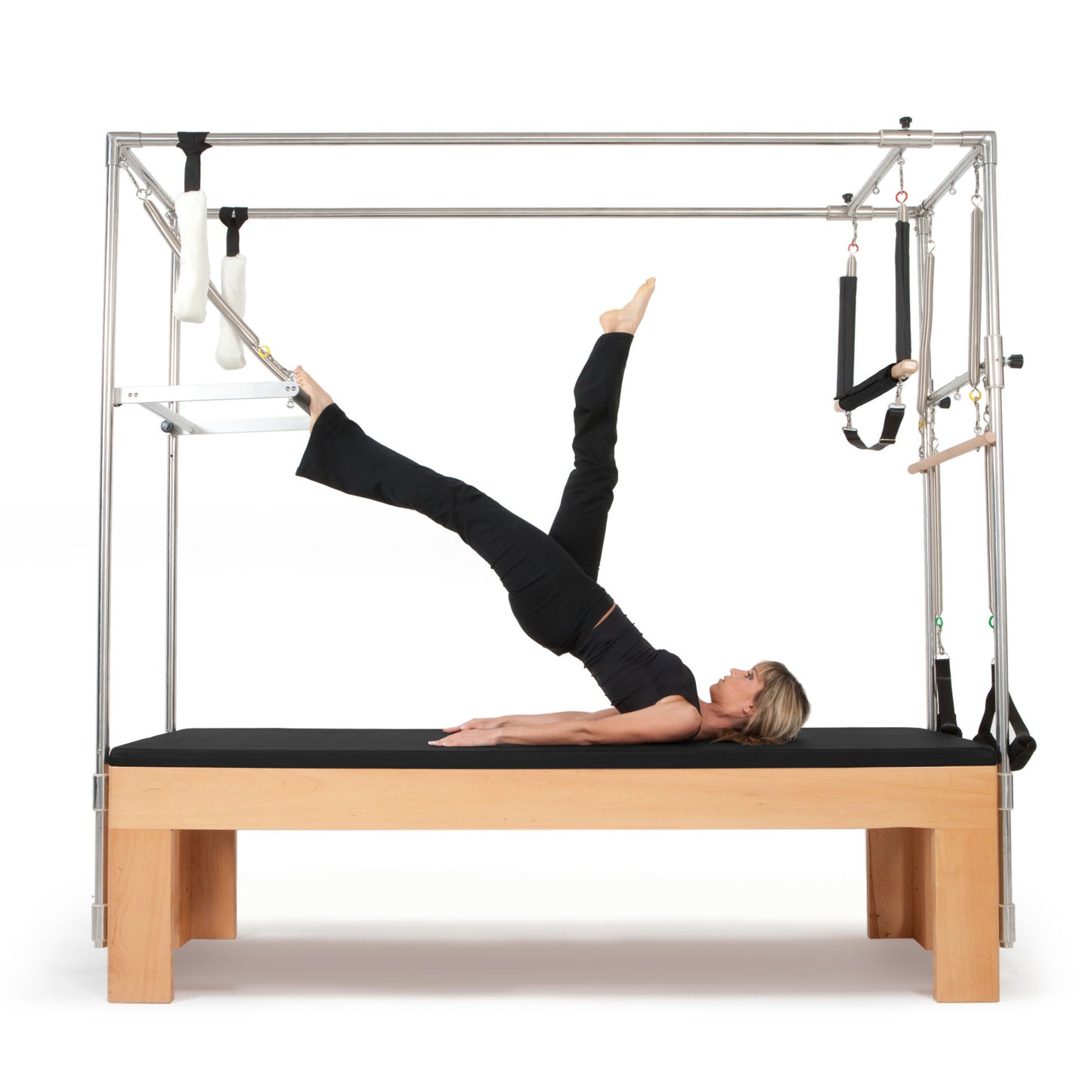 User performing trapeze bar stretches on the Elina Pilates Cadillac trapeze table in a studio setting