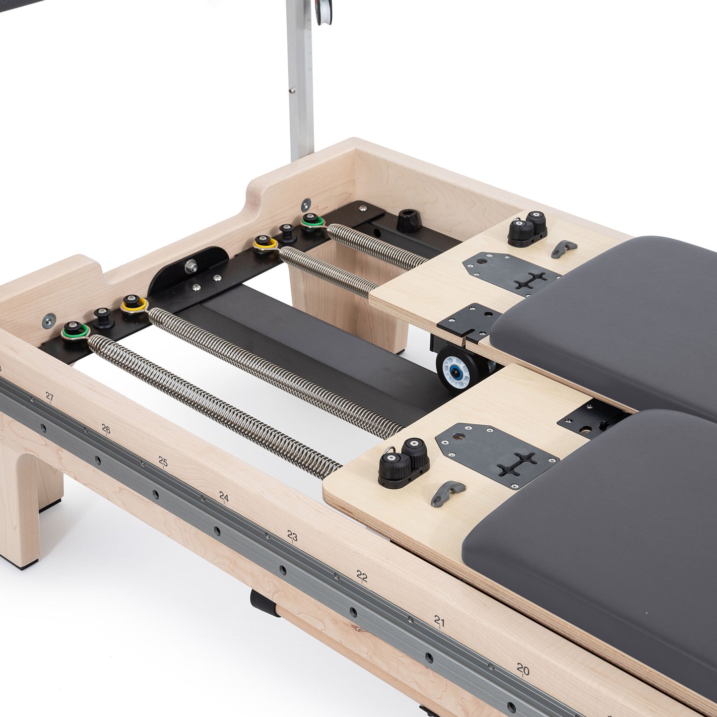 Close-up of the twin double-carriage springs on Elina Reformer with precision wheels and glide rails