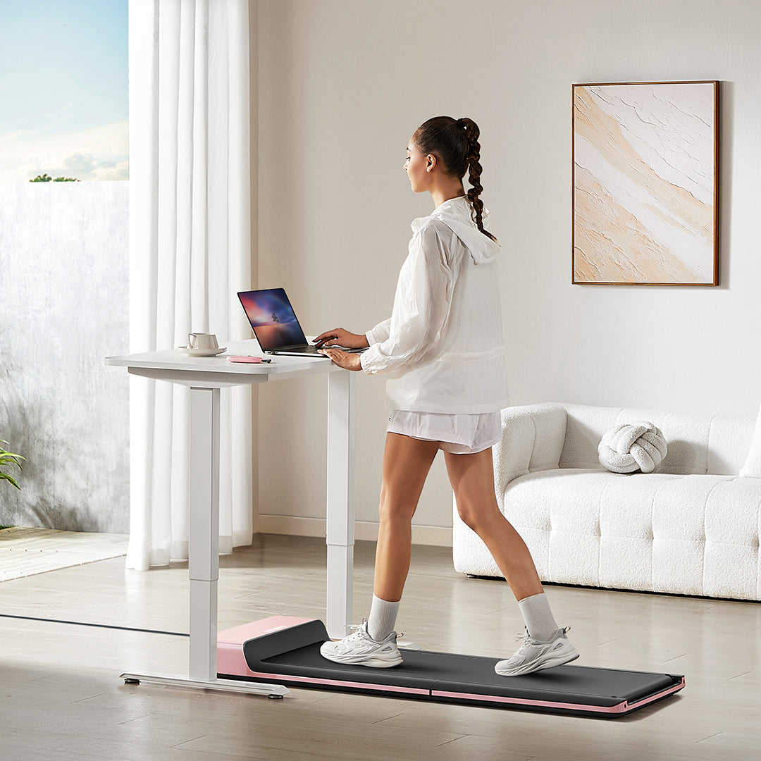 Person using WalkingPad P1 Pink Foldable Treadmill in home