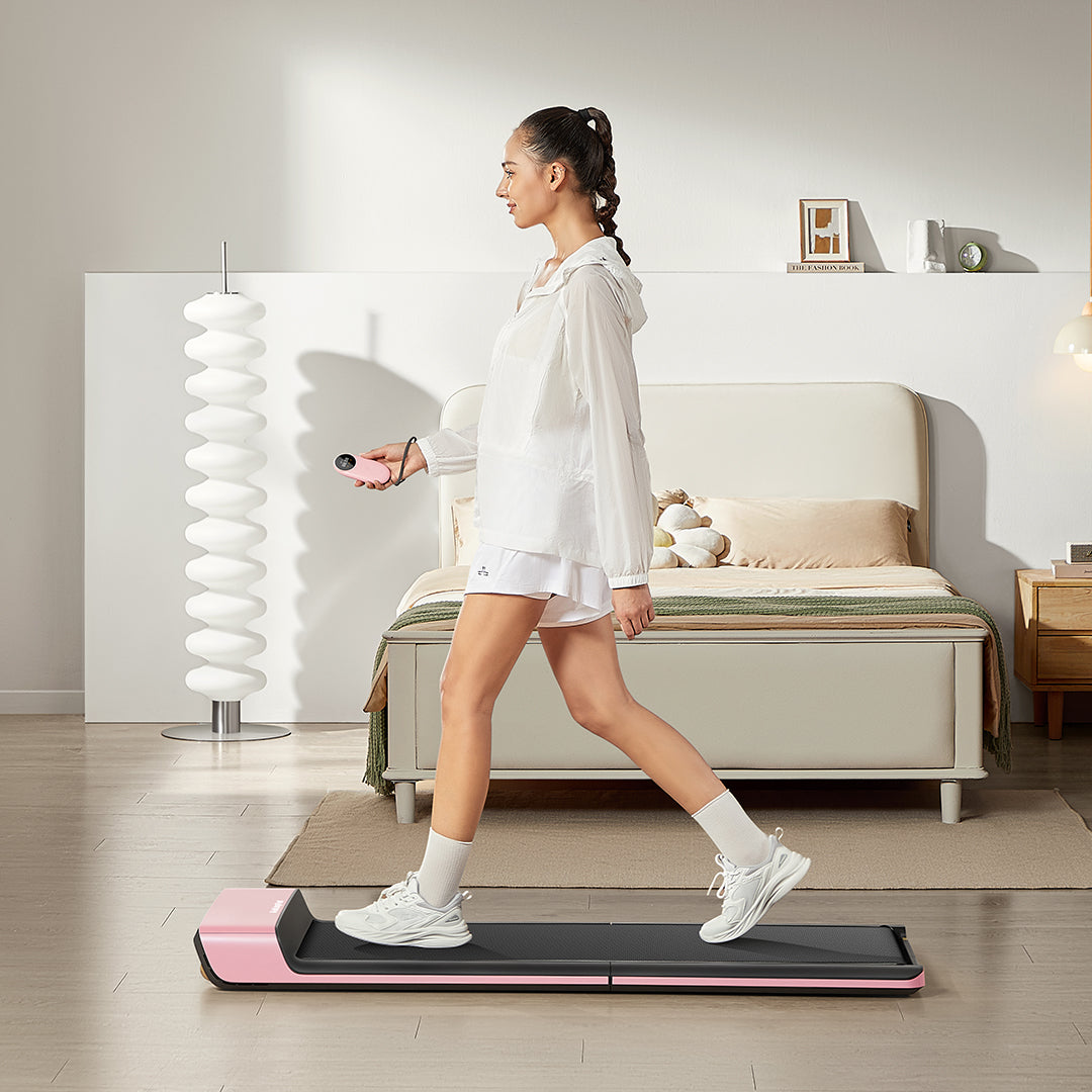 Side view of person using WalkingPad P1 Pink Foldable Treadmill