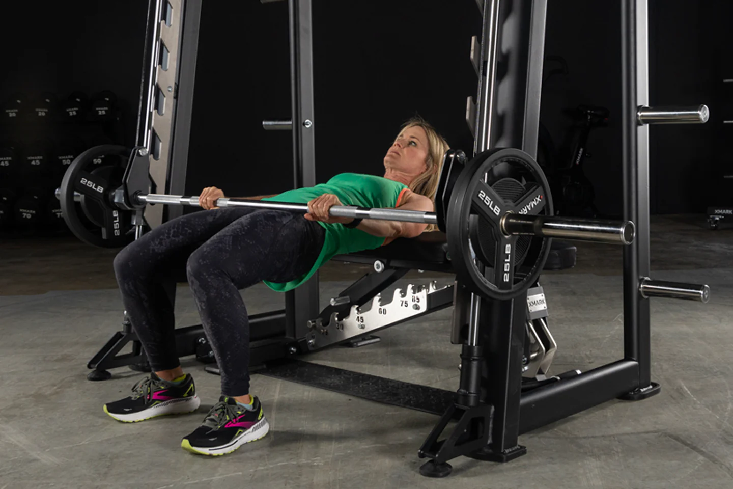 User performing hip thrusts on the XMark Commercial Smith Machine with steel frame and guide rods