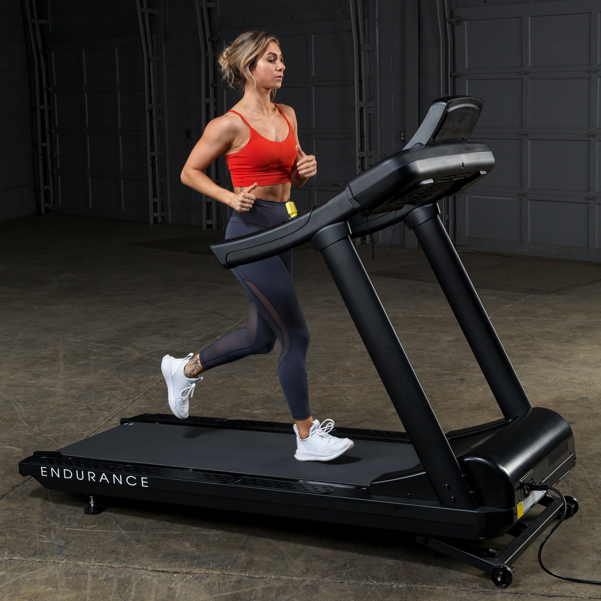Woman running on the Body-Solid Endurance T150 Commercial Treadmill