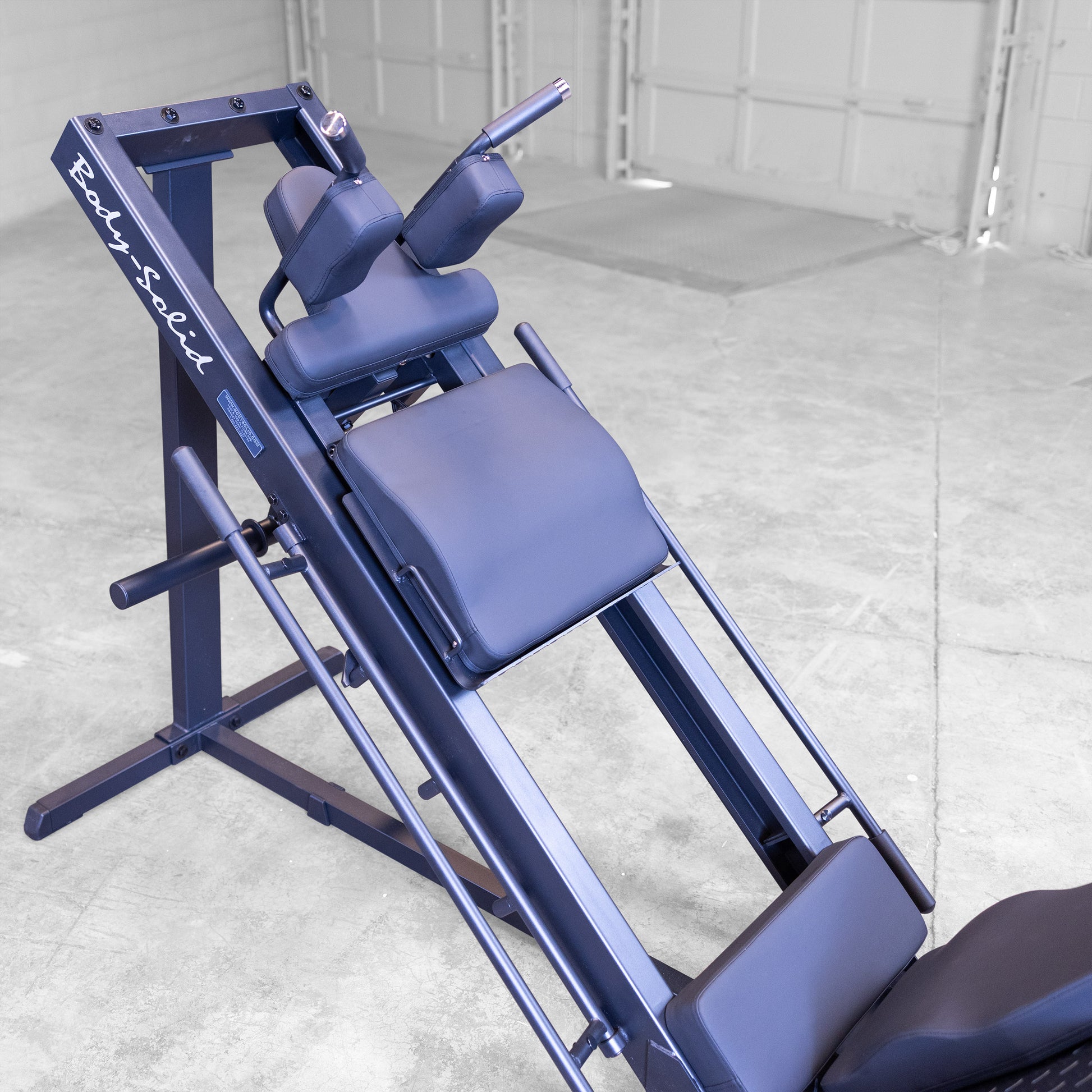 Flip-back pad adjusted for hack squat position on Body‑Solid GLPH1100B