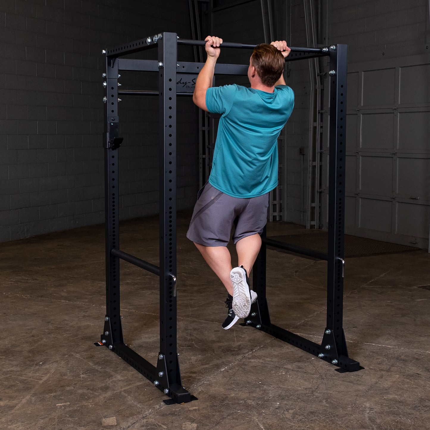 Man performing pullup on the Body‑Solid GPR400 power rack in home gym