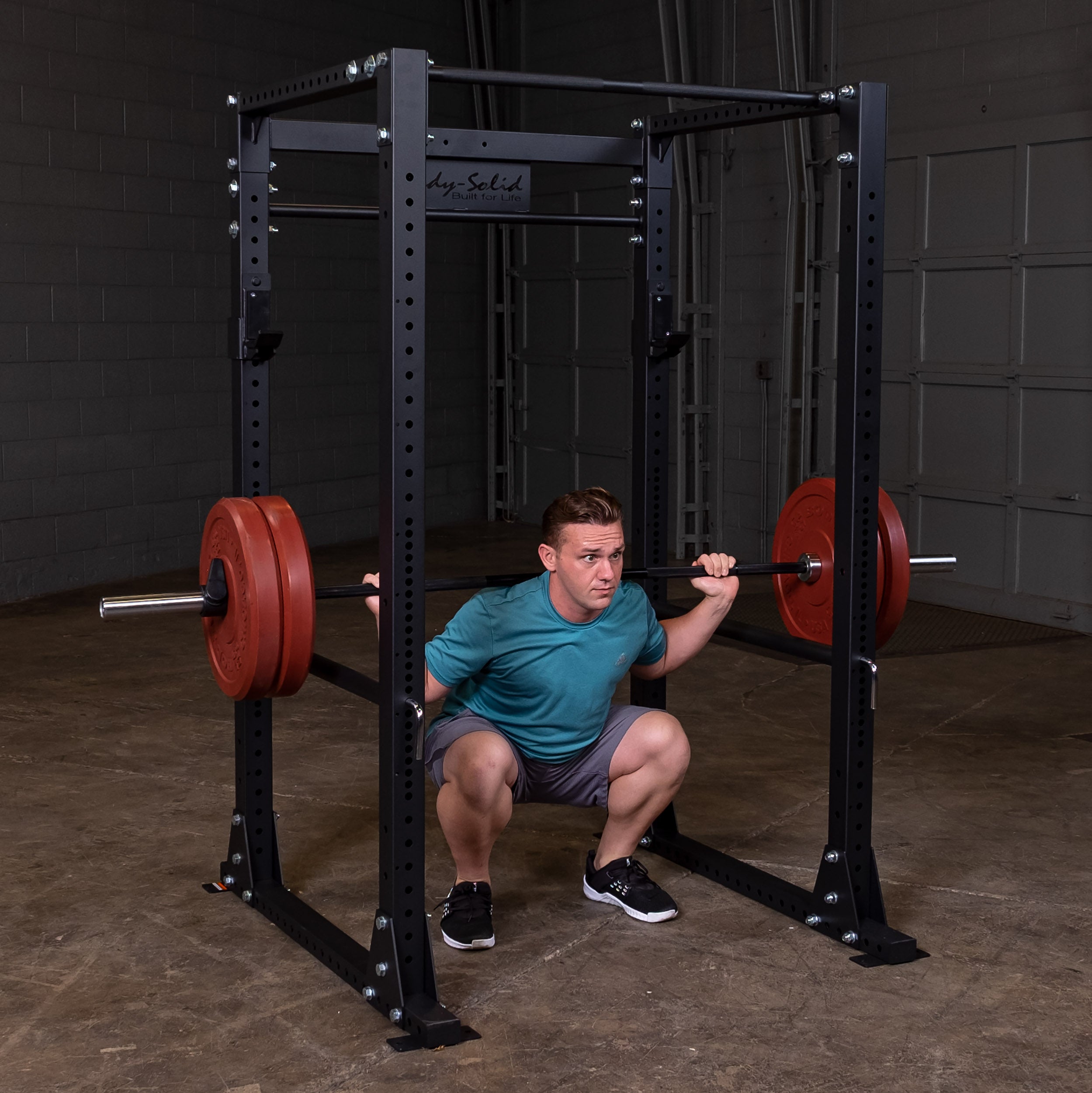 Man performing squats on the Body‑Solid GPR400 power rack in home gym