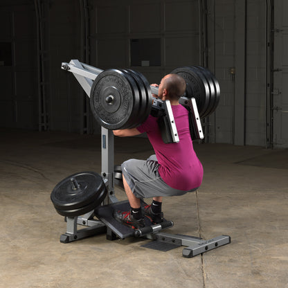 Athlete performing leverage squats on Body-Solid GSCL360 leg workout machine.