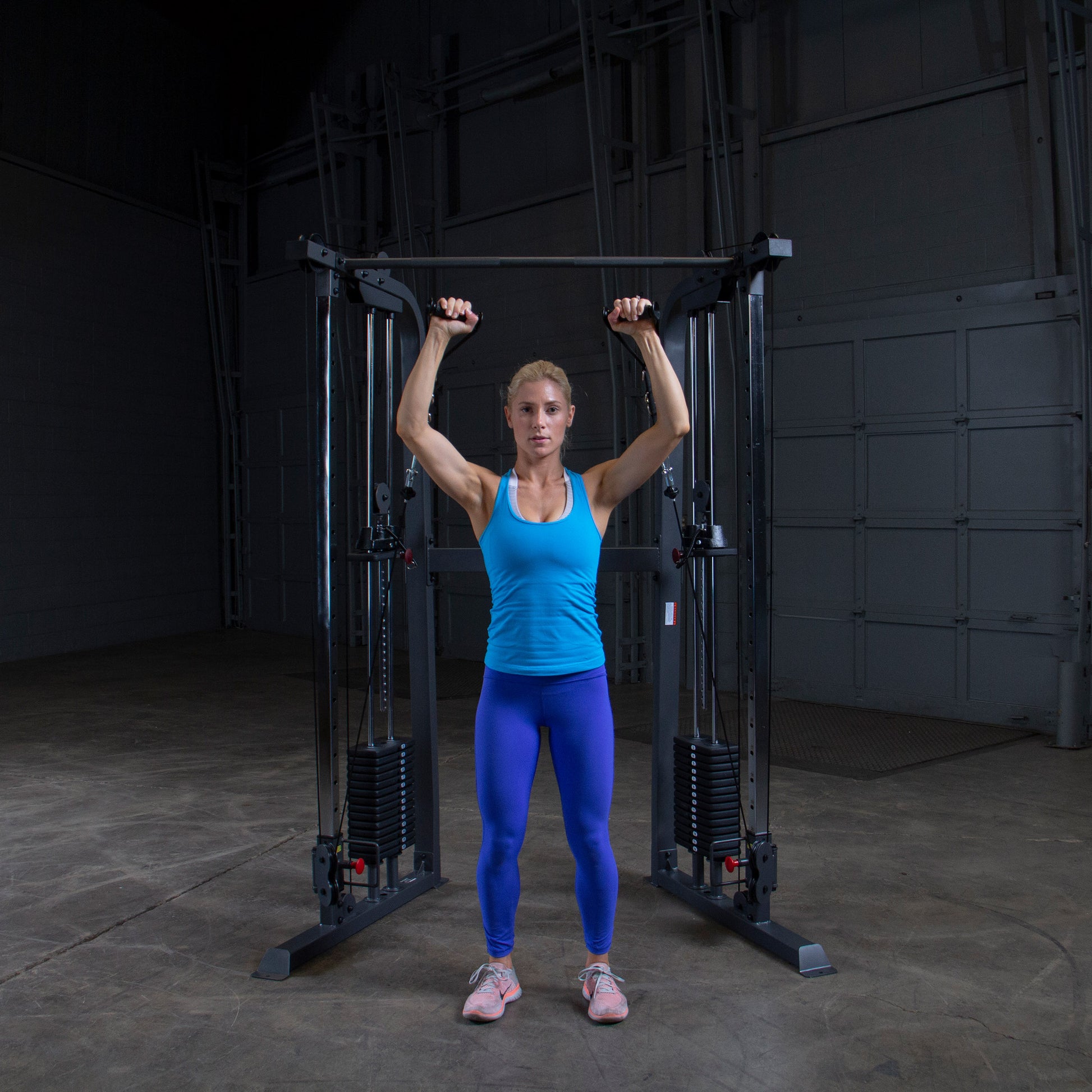 Athlete performing a shoulder workout on Body-Solid Powerline PFT100 Functional Trainer with smooth cable operation.