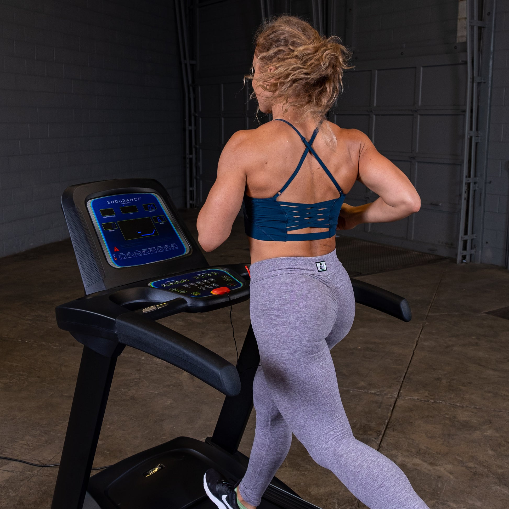 Person jogging on the Body-Solid Endurance T25 Folding Treadmill during a home workout.