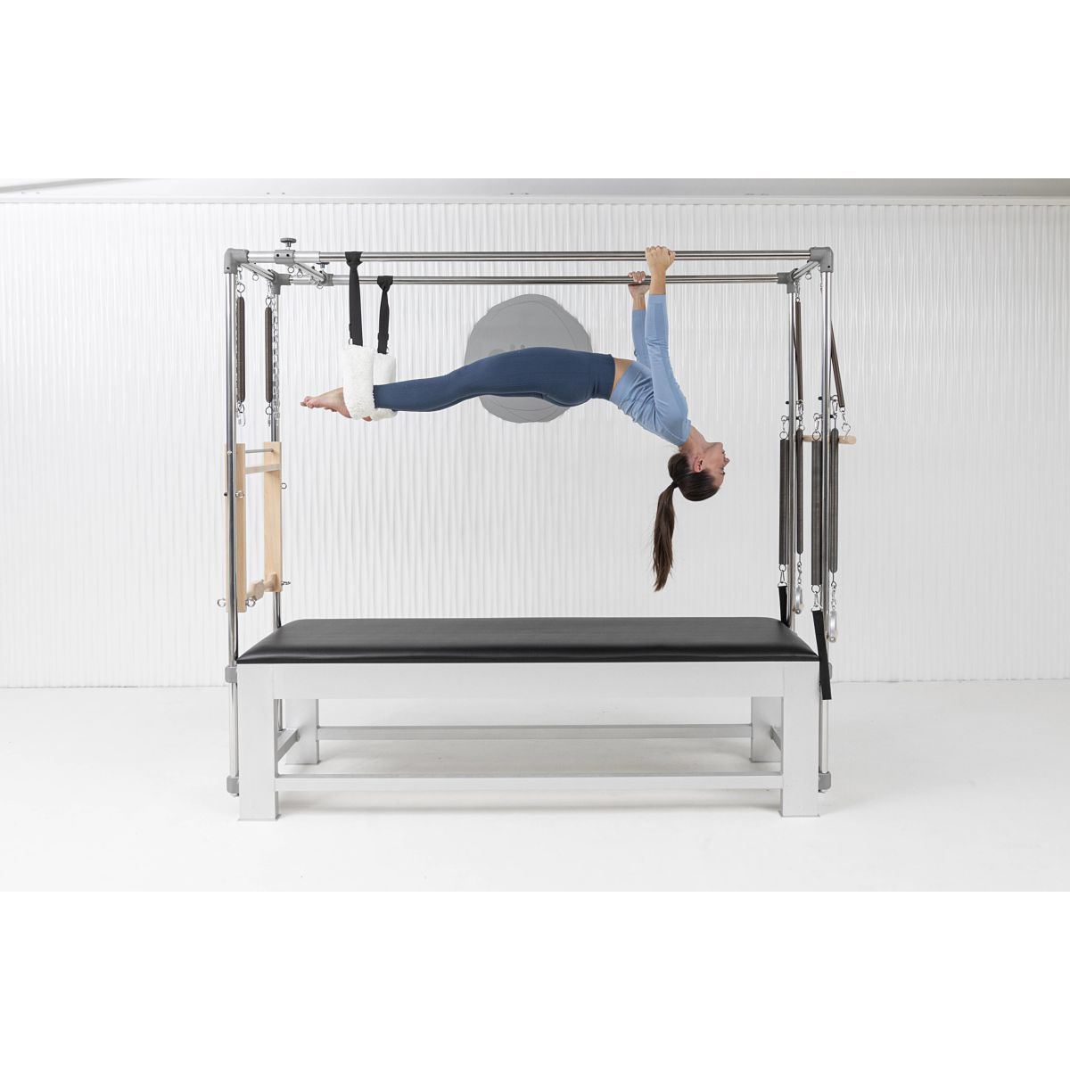 Woman doing workout on the Elina Pilates Classic Aluminum Cadillac trapeze