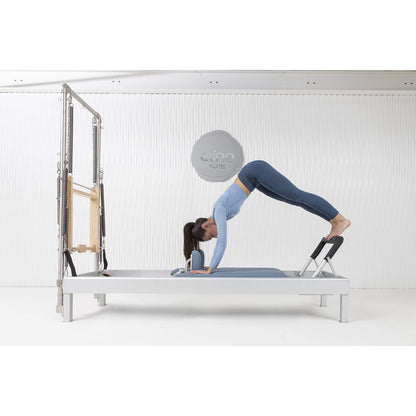 User completing workout on the Elina Pilates Classic Aluminum Reformer 86″ in a studio setting.