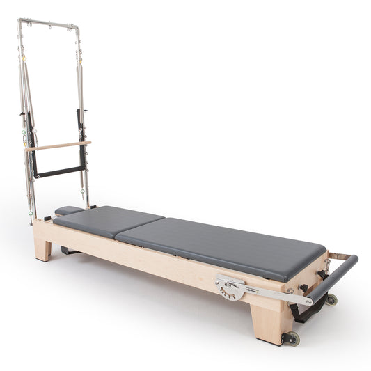 Full view of Elina Pilates Elite Wood Reformer with Tower, grey upholstery in studio setting