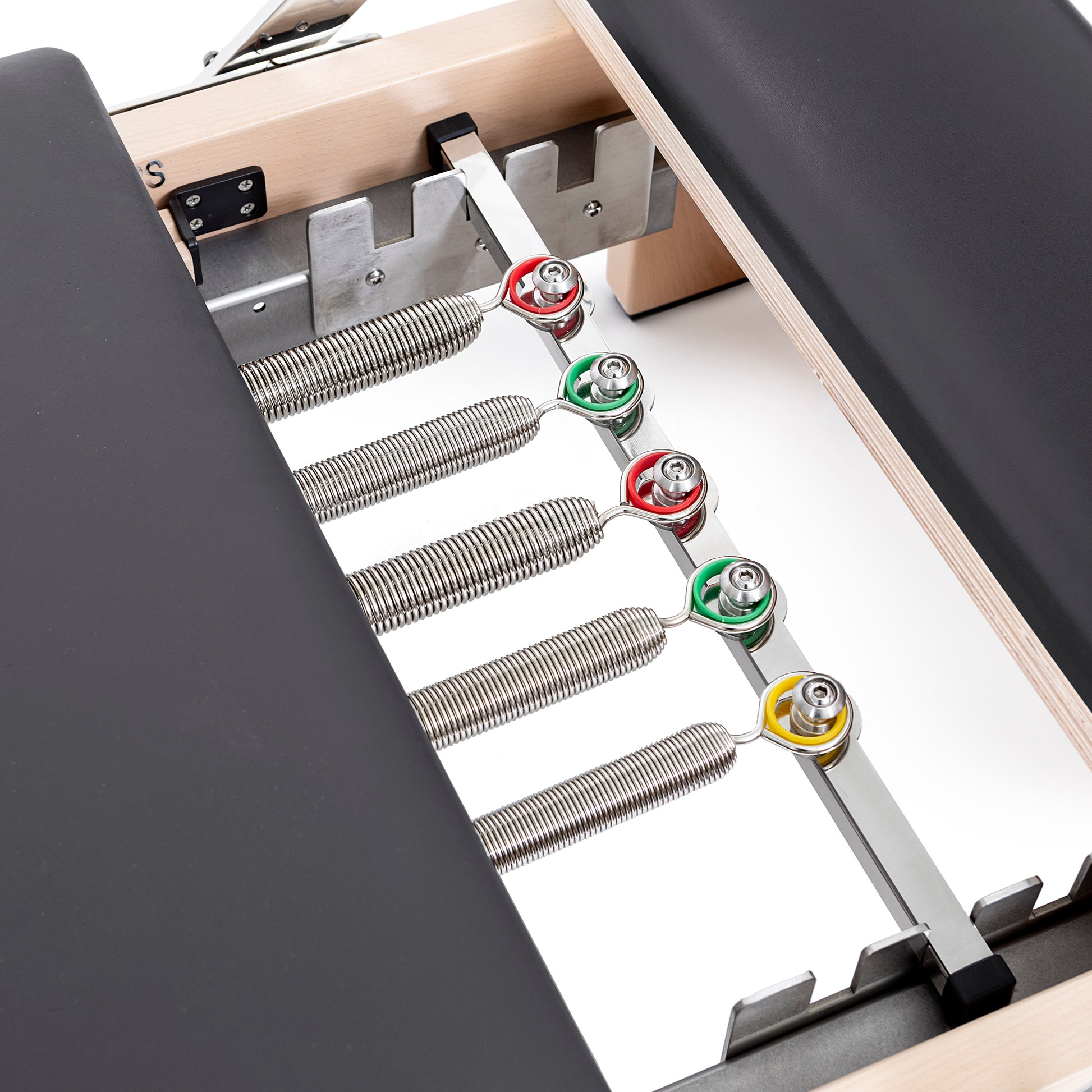 Set of color-coded resistance springs included with the Elina Pilates Wooden Reformer Lignum™ for adjustable workout intensity