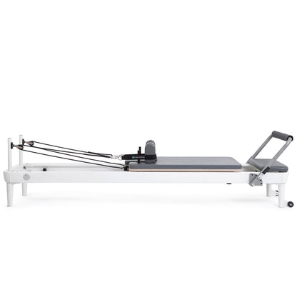 Side profile view of the Elina Pilates Nubium Reformer showcasing the sleek aluminum frame and grey upholstery