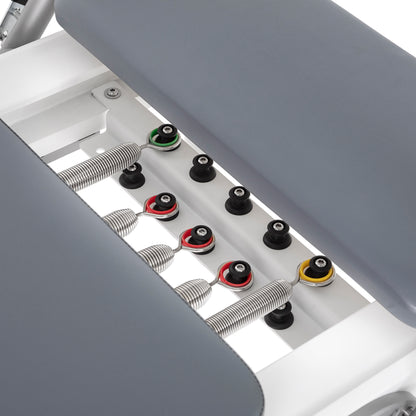 Color-coded alloy springs attached to the Elina Pilates Nubium Reformer showing different resistance levels