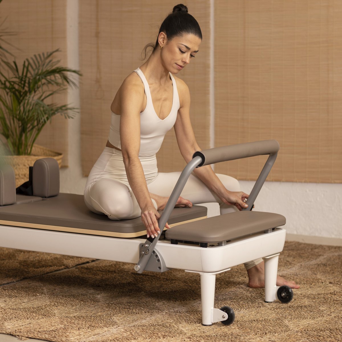 Pilates instructor demonstrating exercises on the Elina Pilates Nubium Reformer in a studio setting