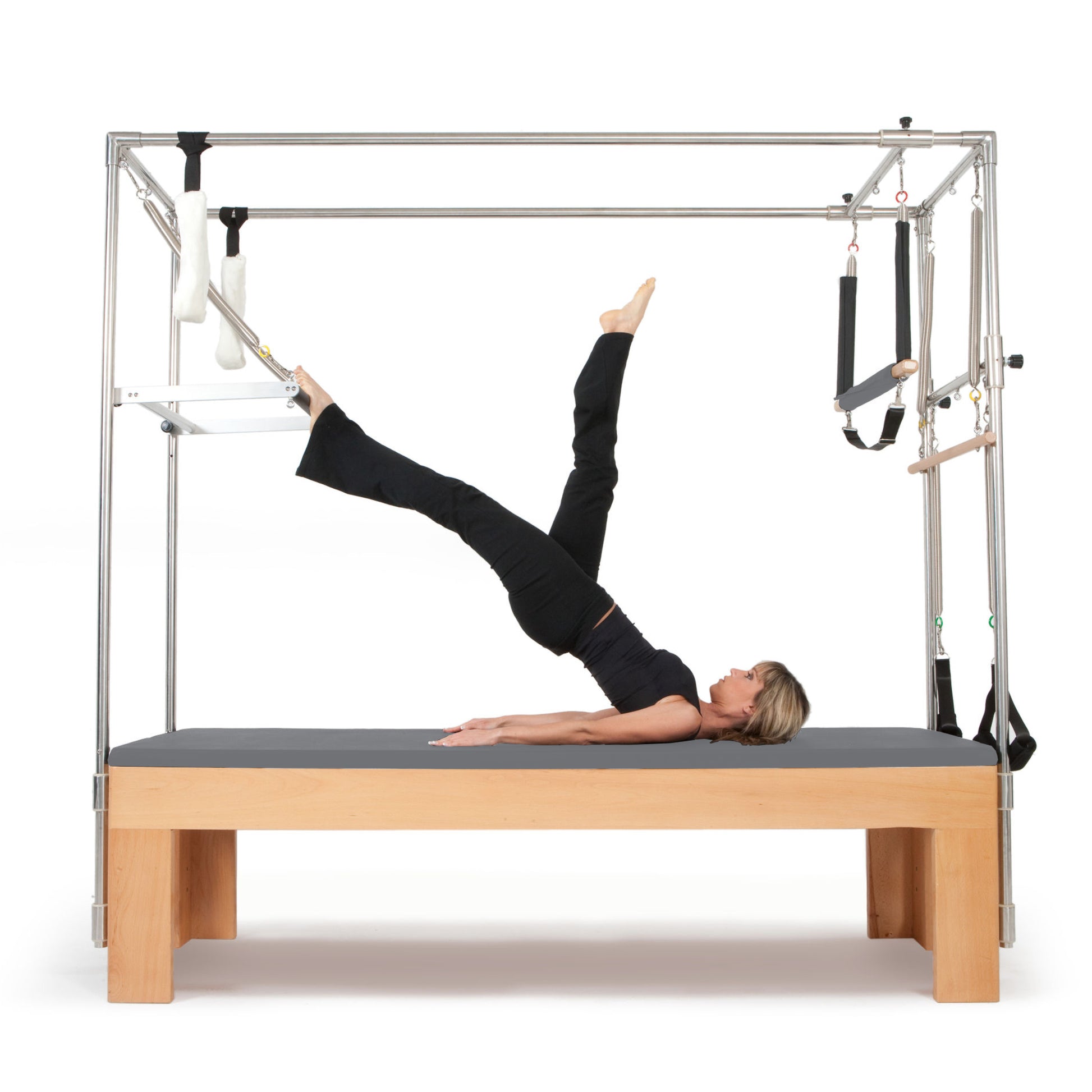 User performing trapeze bar stretches on the Elina Pilates Cadillac trapeze table in a studio setting
