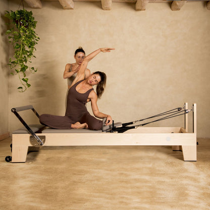 Pilates instructor performing strengthening exercises on Elina Pilates Elite Wood Reformer