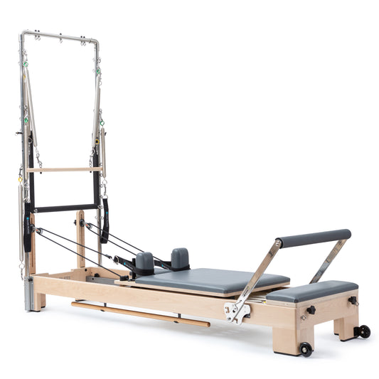 Elina Pilates Wooden Reformer Lignum with Tower in grey upholstery, front view showing solid wood frame and stainless steel tower.