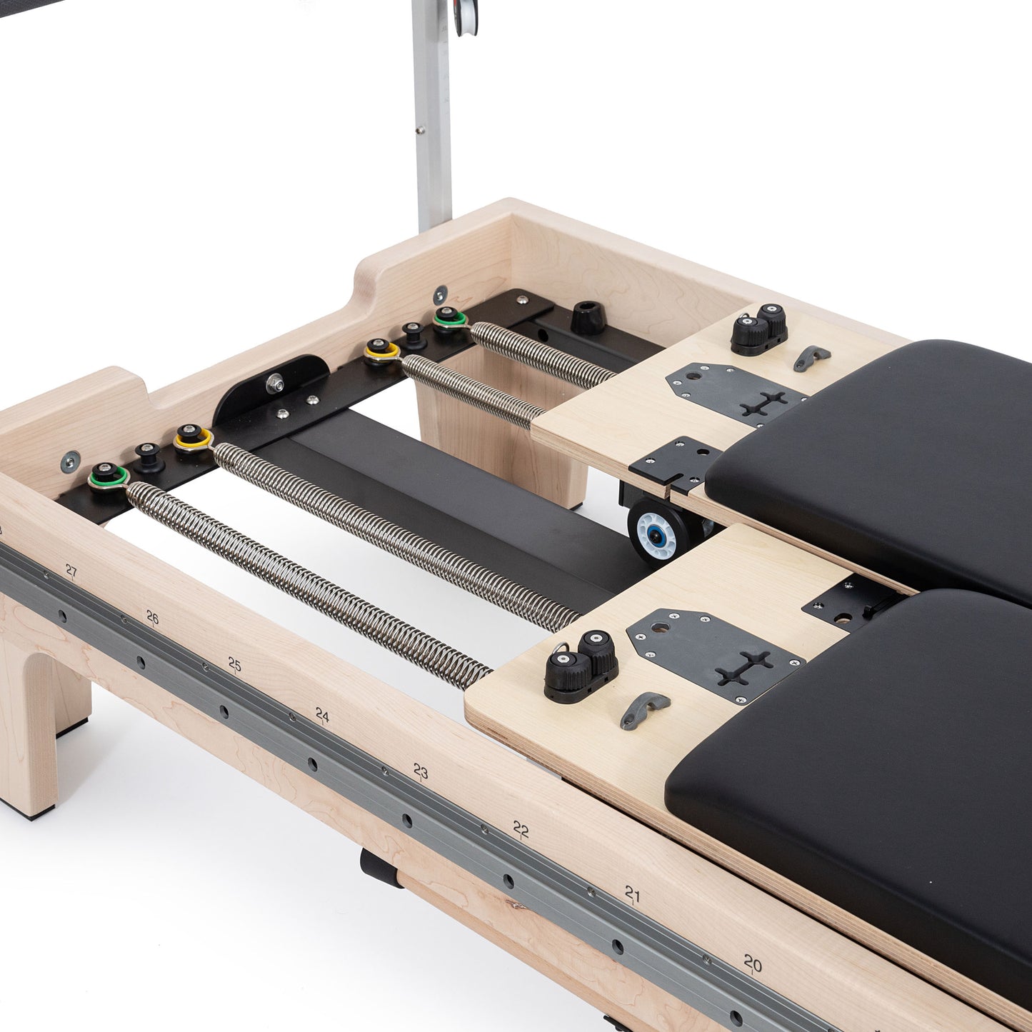 Close-up of the twin double-carriage springs on Elina Reformer with precision wheels and glide rails