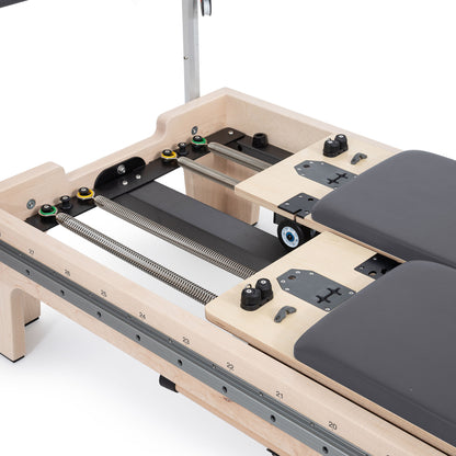 Close-up of the twin double-carriage springs on Elina Reformer with precision wheels and glide rails