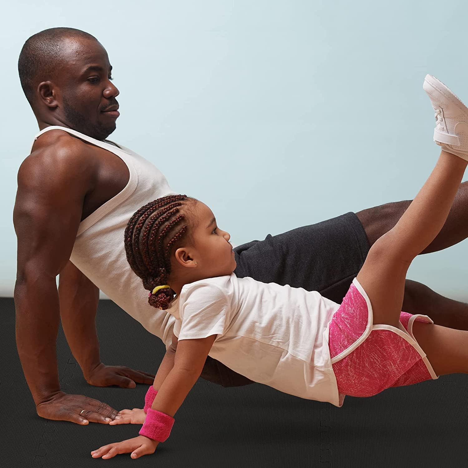 Black EVA foam floor tiles used in a home gym setup with fitness equipment