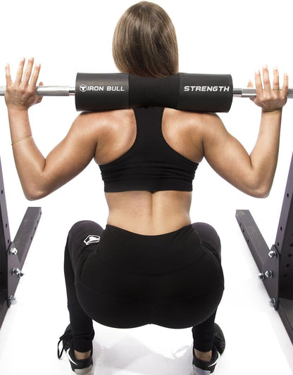 Athlete performing barbell squat using Iron Bull Strength squat pad