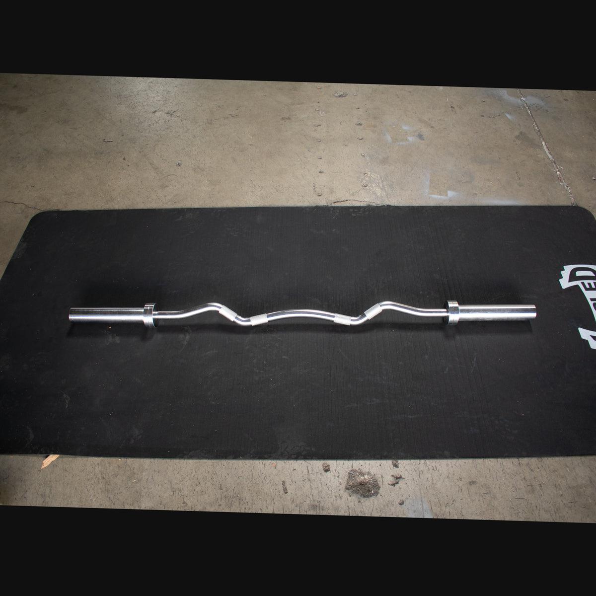 EZ curl bar loaded with plates in home gym setup