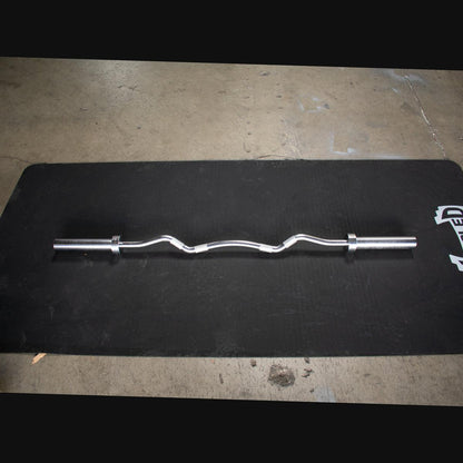 EZ curl bar loaded with plates in home gym setup