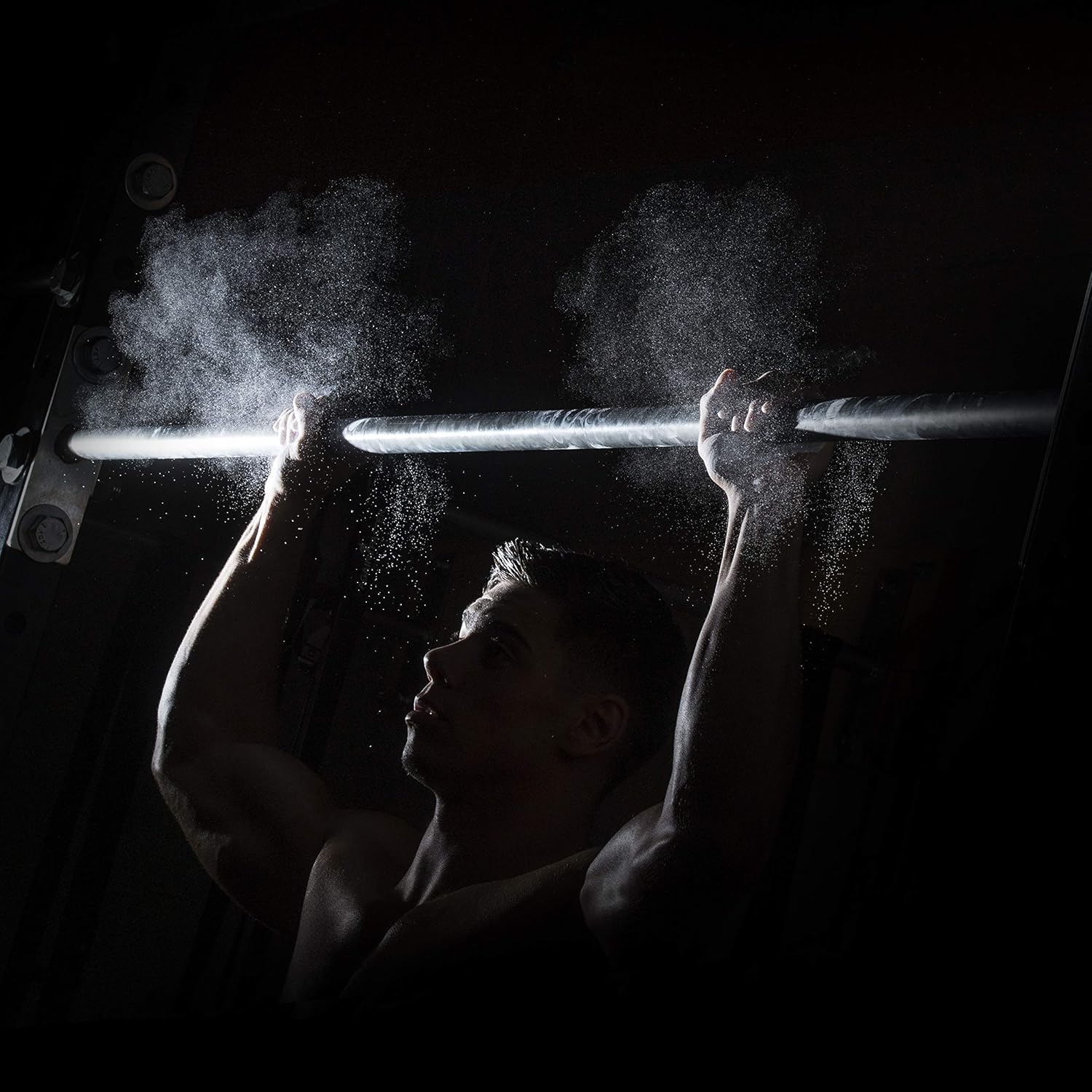Gymnast applying ProsourceFit chalk to hands for improved grip on rings and bars