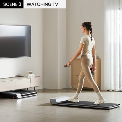 Woman walking on the WalkingPad P1 treadmill under a standing desk setup.