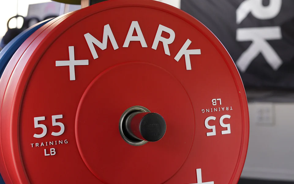XMark chrome bumper plates loaded onto Olympic bar