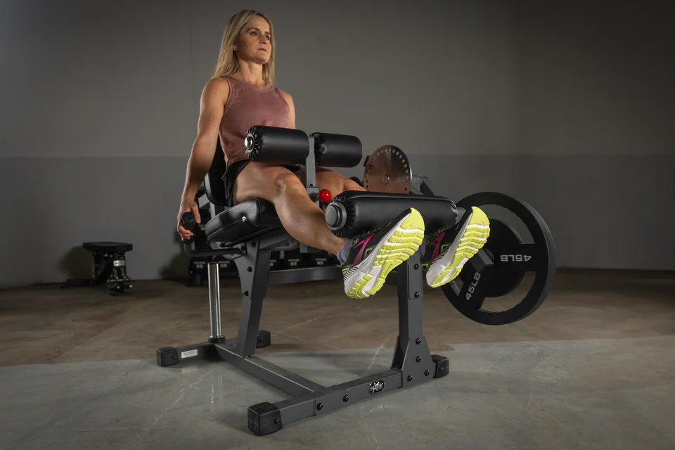 User performing leg extension on XMark Machine