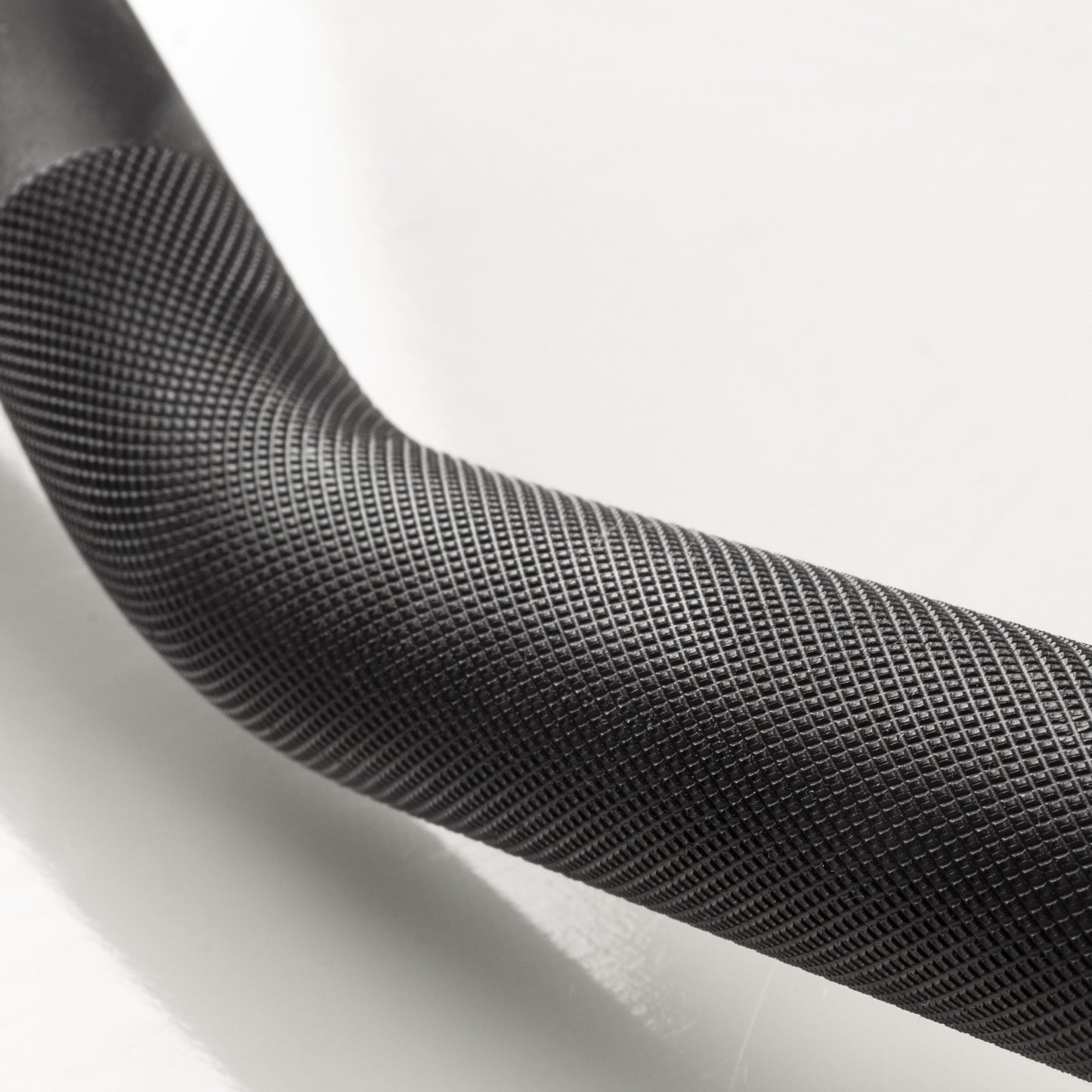 Close-up view of XMark Lumberjack curl bar knurling and angled grip design