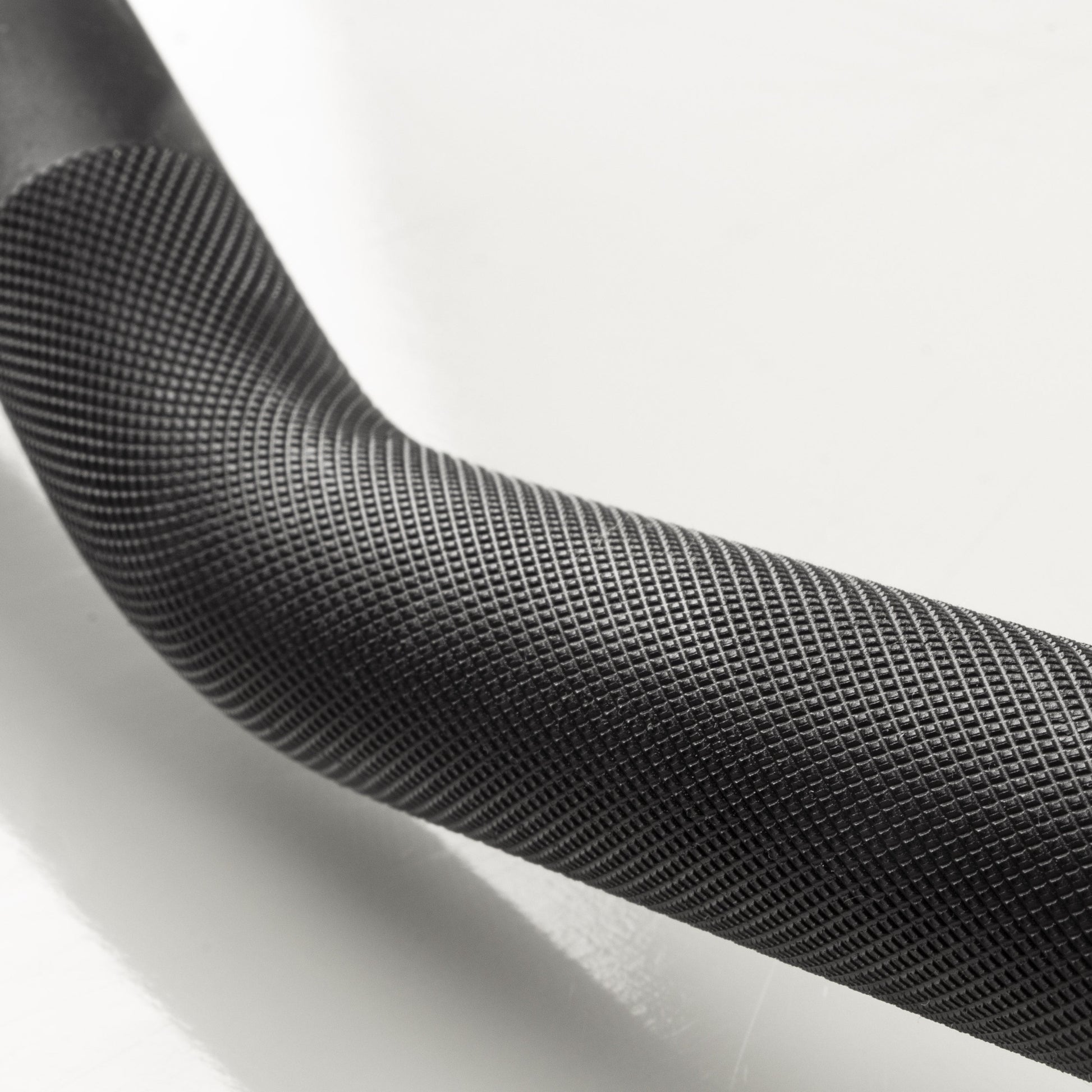 Close-up view of XMark Lumberjack curl bar knurling and angled grip design